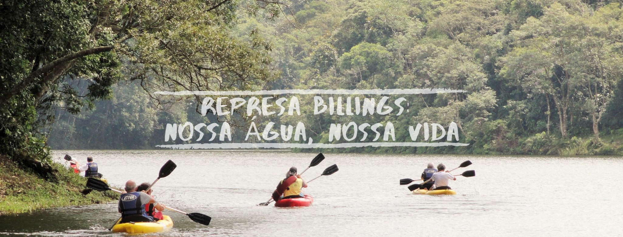 Grupo de pessoas rema em caiaques sobre a Represa Billings, cercada por mata densa e verde. O lago é calmo e árvores se inclinam sobre a água. No centro da imagem, aparece o texto: “Represa Billings: nossa água, nossa vida.”